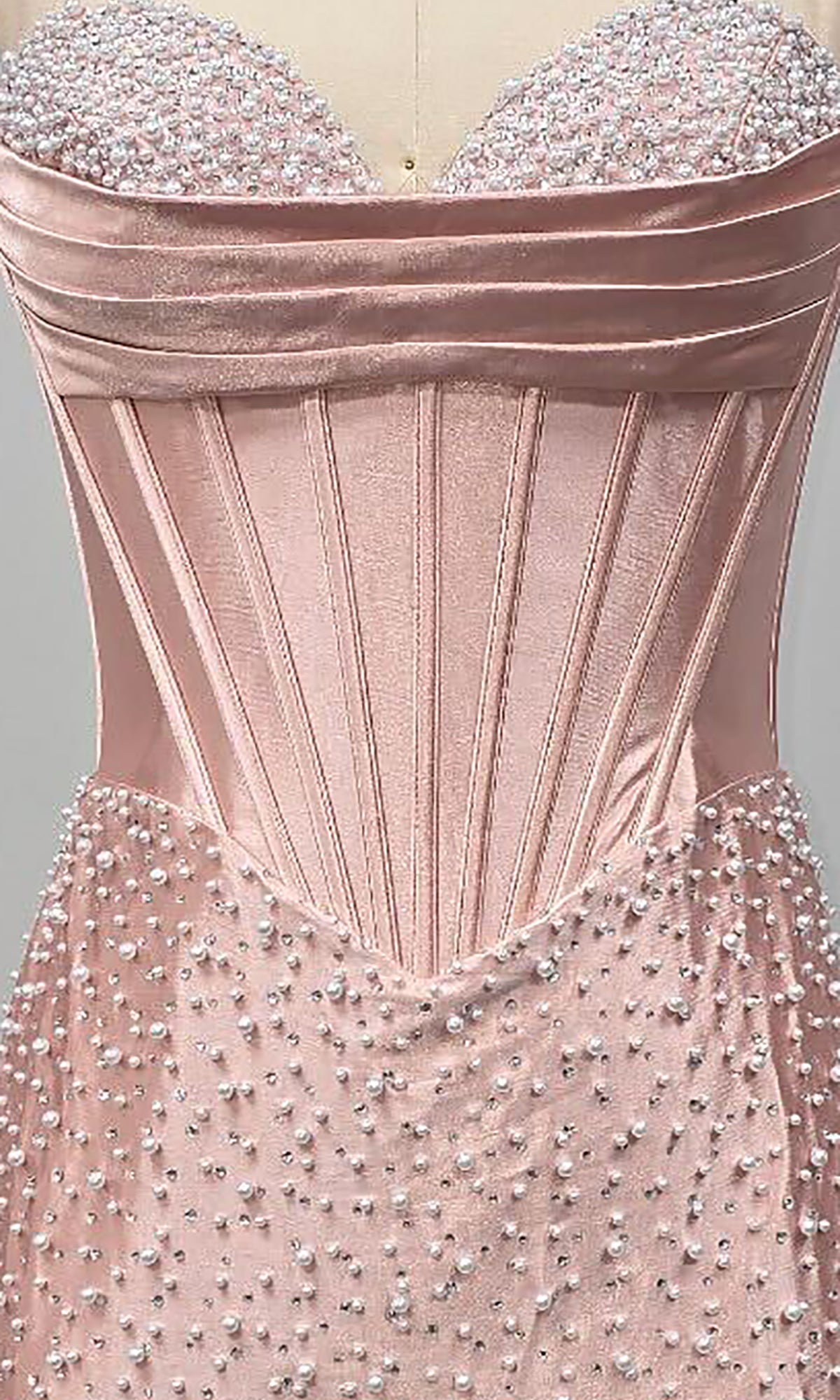 Close-up of the Ava Presley 42568 short homecoming dress, a strapless blush pink satin style with a boned corset bodice and delicate pearl embellishments on the skirt and bodice.